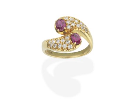 RUBY AND DIAMOND CROSSOVER RING, CIRCA 1976Obliquely set with two oval-cut rubies, between brilliant-cut diamond shoulders, m