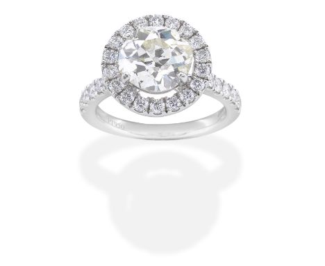 DIAMOND CLUSTER RINGThe cushion-shaped diamond, weighing 2.95 carats, within a brilliant-cut diamond surround, between simila