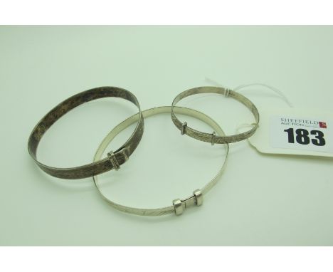 A Hallmarked Silver Bangle, with engraved decoration; together with a child's expanding bangle; and another. (3)