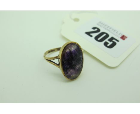 A 9ct Gold Blue John Oval Panel Ring, (noticeably scratched) collet set between bifurcated shoulders (finger size P). 