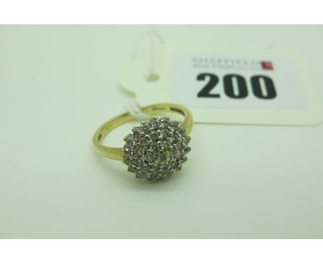 A Modern Cluster Dress Ring, of circular design, claw set throughout, stamped "375" "9KT" (finger size M) (2.5grams). 