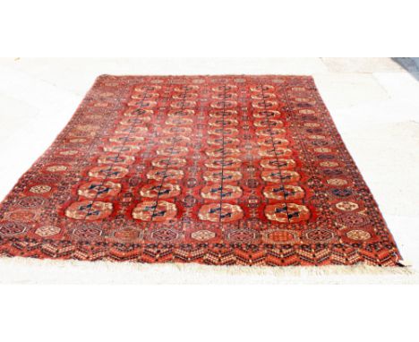 A Yomut Bokhara carpet decorated four rows of flattened guls on a red ground, 112" x 84" approx (slight wear)