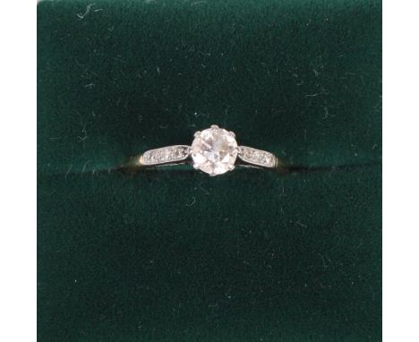 A gold and diamond solitaire ring with diamond chip set shoulders, size K