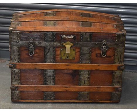 A brass bound domed top trunk with lift-up hinged lid, width 76.5cm.