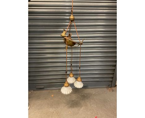 An early 20th century brass ceiling light, with four white glass shades, approx height 115cm.