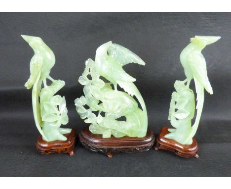 A pair of Oriental jade style exotic birds on flowering branches, on wooden stands, height 21cm, together with a group of exo