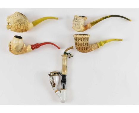 A group of Meerschaum pipes, including one modelled as a dragon, another modelled as a claw holding an egg, another modelled 