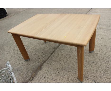 An Ercol oak extending dining table, on shaped supports, 45" wide x 36" deep x 29 1/2" high