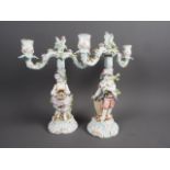 A pair of Continental porcelain candelabra with relief figure, flower and leaf decoration, 11 1/4”