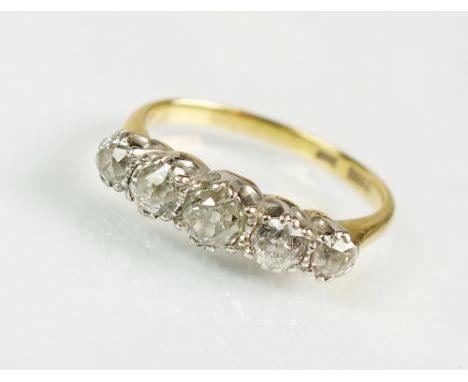 A five stone graduated diamond ring, the five old cut diamonds claw set in white metal to yellow metal shank, stamped '18ct',