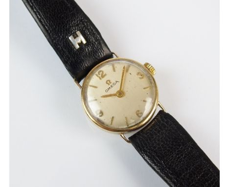 A lady's 9ct gold Omega wristwatch, the circular silvered dial with Arabic numerals and batons, manual wind, with attached bl