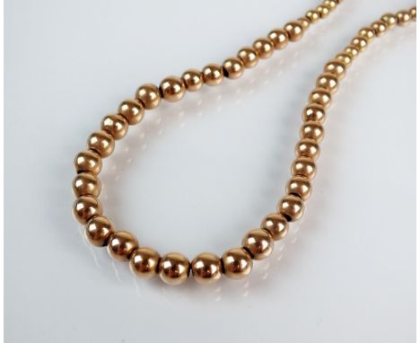 A yellow metal graduated ball necklace, stamped '9ct', with bolt ring clasp, 32cm long, weight 13gms