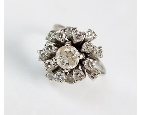 An 18ct white gold diamond cluster ring, designed as a central raised brilliant cut diamond within a surround of sixteen furt