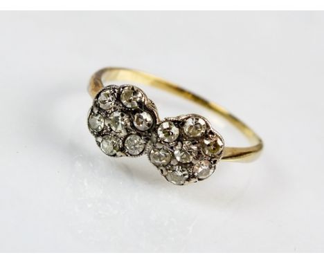 An early 20th century diamond set floral cluster ring, designed as two eight cut diamond set flower heads claw and collet set