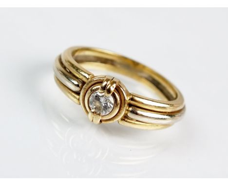 A single stone diamond ring, designed as a brilliant cut diamond claw and collet set in yellow metal to tapered reeded yellow