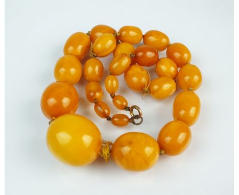 A graduated amber bead necklace, comprising twenty-five oval amber beads measuring from approx 26mm to 7mm, with bolt ring cl