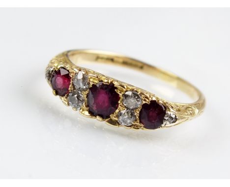 An early 20th century ruby and diamond cluster ring, designed as three graduated oval mixed cut rubies interspersed with five