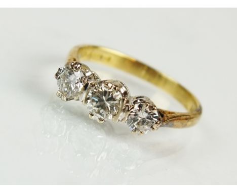 An 18ct gold three stone graduated diamond ring, designed as a row of three brilliant cut diamonds claw and bar set in white 