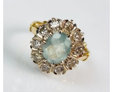 An aquamarine and diamond oval cluster ring, designed as an oval mixed cut faceted aquamarine claw set within ten brilliant c