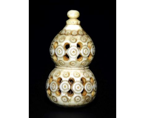 A bone Japanese carved and pierced double gourd netsuke, with screw top, the body with repeated circular incised designs, pro