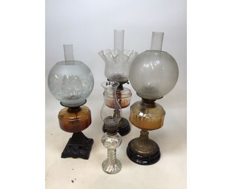 Three oil lamps with decorative glass shades, one with cast iron decorative base, two with brass bases with one other H:57cm 