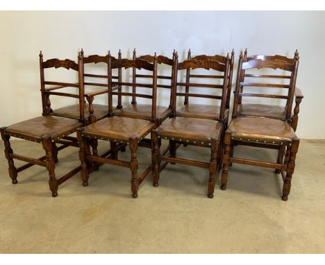 A set of eight late 19th early 20th century country oak ladder back dining chairs with leather studded seats. To include two 