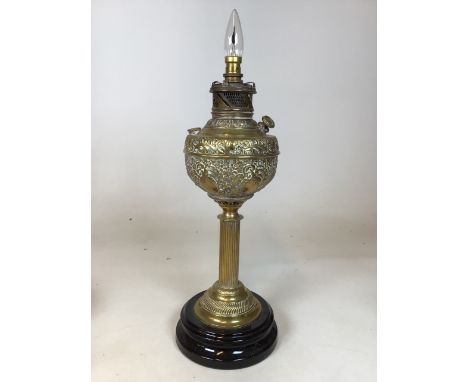 A brass oil lamp on ceramic base, converted to electric. Stamped The New Rochester made in the USAW:18cm x H:46cm