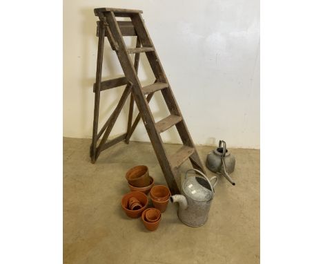 Galvanised watering cans, terracotta pots and vintage step ladders. 