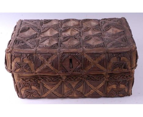 * A late 19th century Peruvian cowhide trunk, of rectangular form with applied leather strap-work decoration and hinges, with