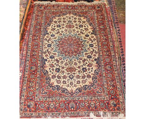 * A Persian woollen Tabriz rug, the cream ground decorated with a central medallion issuing scroll flowers and foliage within