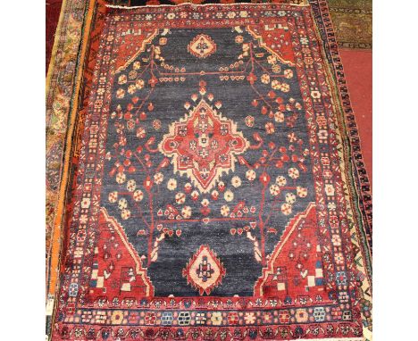 * A Persian woollen rug, having a deep pile, the blue ground having a central medallion and further decorated with geometric 