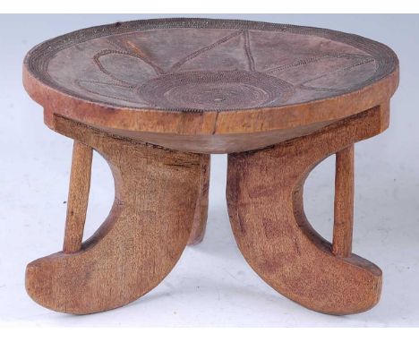 An African hardwood stool, the dished seat with copper beaded decoration, raised on splayed tripod supports, Kamba People, Ke