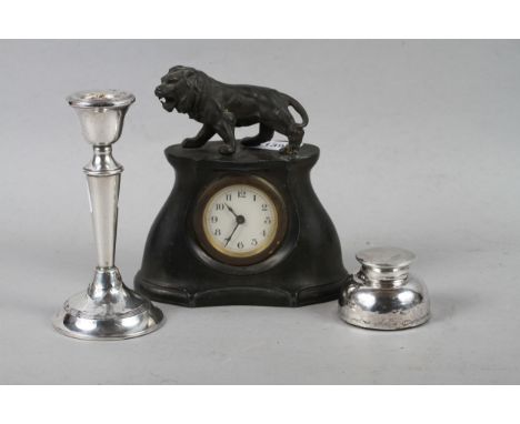 A pewter cased mantel clock with a lion surmount, a silver inkwell and a filled silver candlestick 