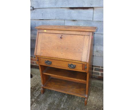 An oak fall front desk with fitted interior over one long drawer and open shelf, 26" wide x 12" deep x 36" high 