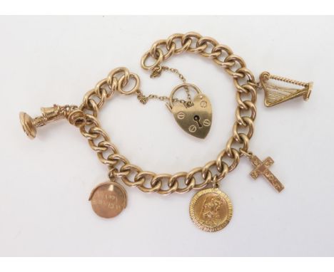 A 9ct gold charm bracelet with heart shaped clasp with five 9ct gold charms to include a harp and telephone, weight 38.6gms C