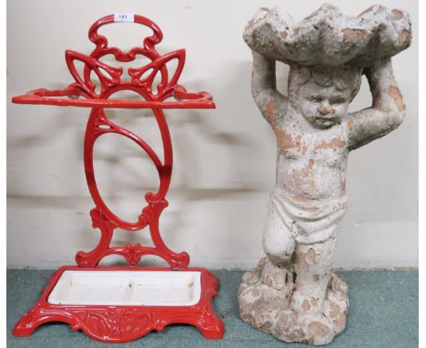 A 20th century red painted cast free standing umbrella/stick stand and a stone ware garden birdbath in the form of a cherub (