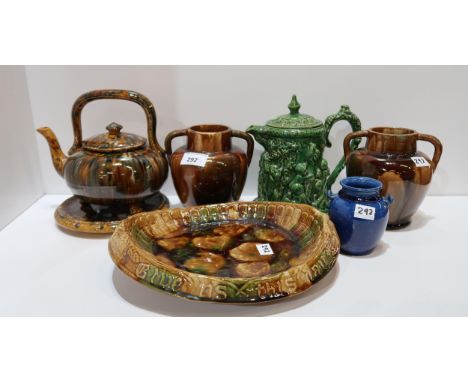 A collection of Dunmore pottery including a teapot on stand, bread plate, moulded green glazed lidded jug decorated with bacc