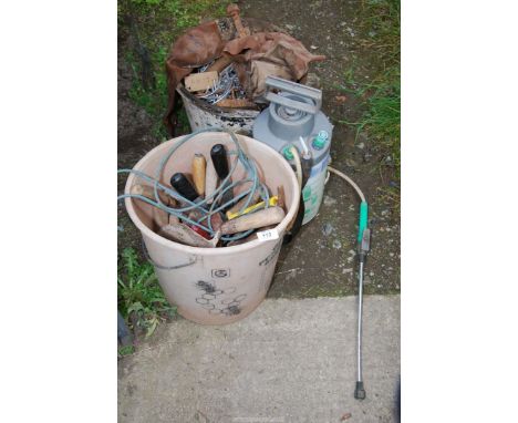 A small garden sprayer, bucket of nails and a bucket of garden tools.
