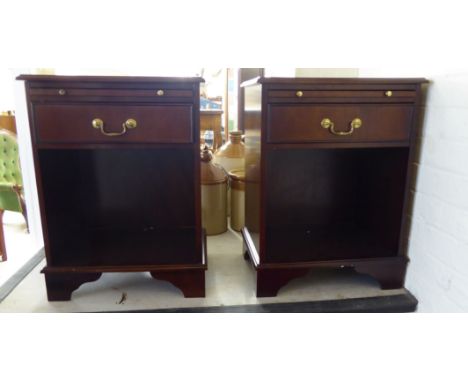 A pair of modern mahogany finished bedside tables, each with a brushing slide, a drawer and an open shelf, raised on bracket 