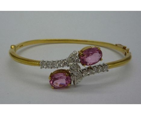 An 18ct gold, diamond and tourmaline crossover bangle, with two oval pink tourmalines, four Marquis and twelve brilliant cut 