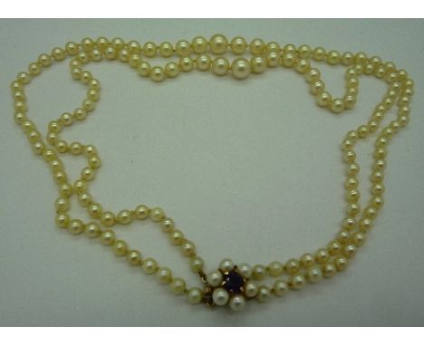 A pearl necklace with yellow metal clasp