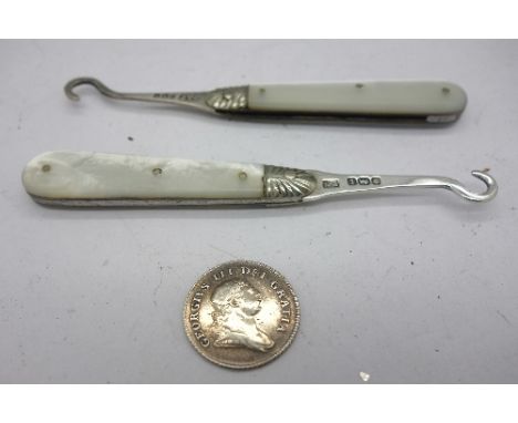 Two silver and mother of pearl button hooks and a George III silver coin, Bank Token Five Pence Irish 1806
