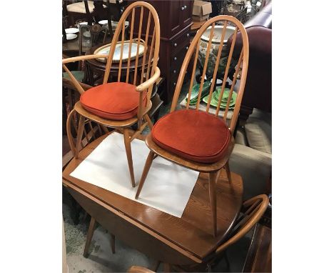 A Blonde Ercol dining table with four matching Windsor chairs