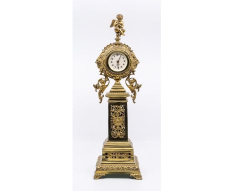 A Victorian style brass columnar mantel clock by Meridian of pierced foliate design and surmounted by winged putto playing a 