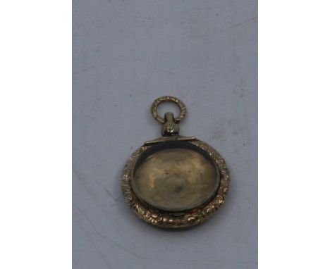 A 19th century 15ct gold circular locket with engine turned decoration, hinged glazed cover and with suspension loop, 5cm lon