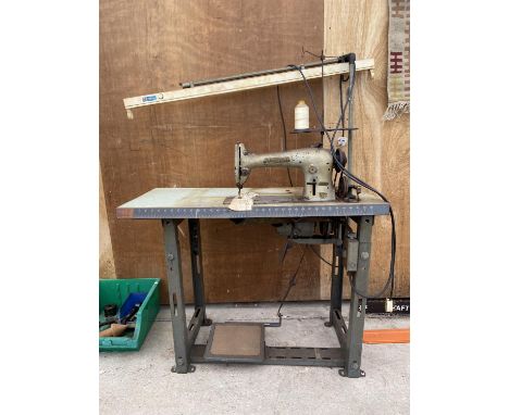 AN INDUSTRIAL SINGER SEWING MACHINE WITH WORK TABLE AND WORK LIGHT ATTATCHED 
