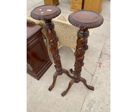 A PAIR OF VICTORIAN STYLE MAHOGANY TORCHERES ON TRIPOD BASES WITH FRUIT AND LEAF COLUMN DECORATION 