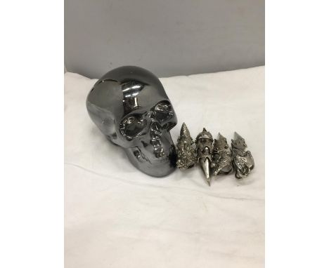 A CERAMIC SILVER COLOURED SKULL MONEY BOX AND FOUR JOINTED TALLON RINGS 