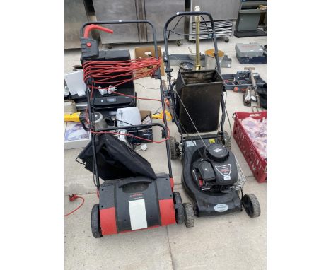 A PETROL LAWN MOWER WITH BRIGGS AND STRATTON ENGINE AND A HECKMAN SCARIFIER 