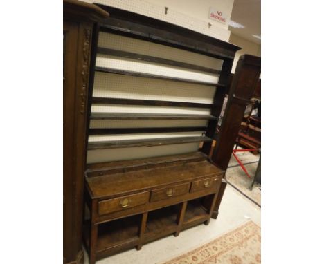 A 19th Century oak dresser, the three tier boarded plate rack with cup hooks and dummy drawers over three drawers on square s